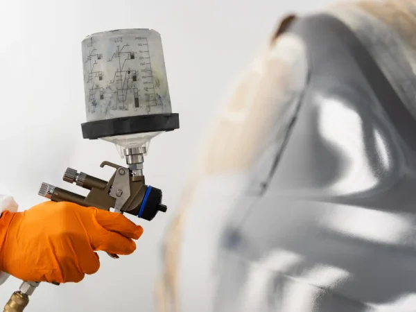 Demonstração de pintura eletrostática com pistola de pintura, destacando o funcionamento e a aplicação industrial da técnica de pintura eletrostática para obtenção de acabamento uniforme e eficiente.