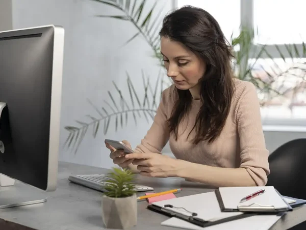Mulher no escritório analisando a importância de um portfólio e dicas sobre como montar um para potencializar a carreira profissional.