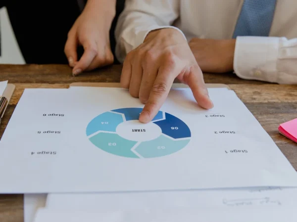 Pessoa analisando um gráfico de planejamento de vendas e operações (S&OP) em uma reunião de negócios, ilustrando como estruturar um processo de S&OP funcional.